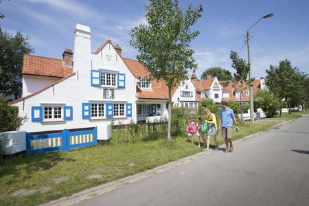 A family walks past holiday homes at the Roompot Breeduyn Village holiday park