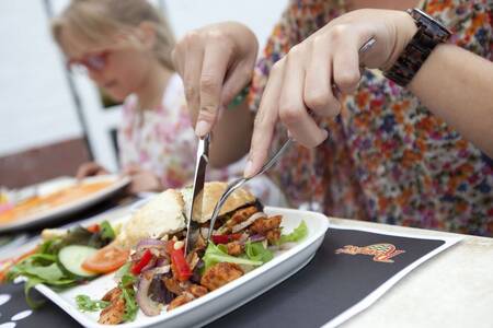 A family dines in a restaurant at the Roompot Buitenhof Domburg holiday park