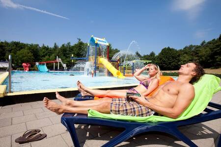 People on sun loungers at the outdoor pool of Holiday Park Roompot Buitenplaats De Hildenberg