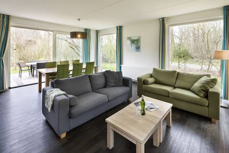 Living room with large windows of a holiday home at the Roompot Buitenplaats De Marke van Ruinen