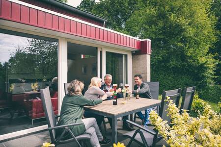 People enjoy a drink on the terrace at a holiday home at Roompot Bungalow Park Schin op Geul
