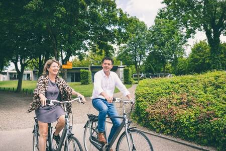 People cycle between holiday homes at Holiday Park Roompot Bungalow Park Schin op Geul