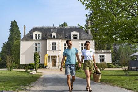 A couple walks through the Roompot Château des Marais holiday park