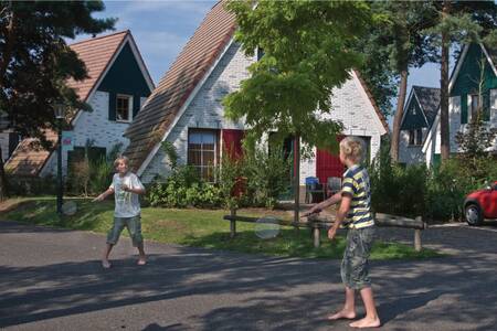 2 children playing badminton between the holiday homes at the Roompot De Katjeskelder holiday park