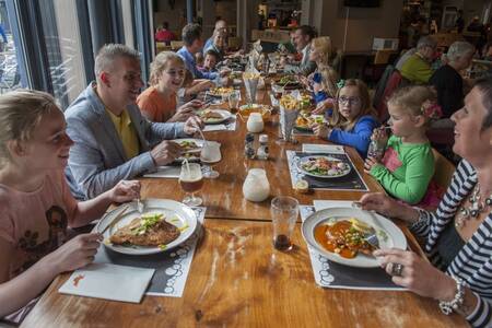 Family dines in the restaurant at the Roompot De Katjeskelder holiday park