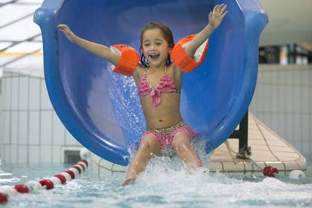 Child slides down the slide in the indoor pool of the Roompot De Katjeskelder holiday park