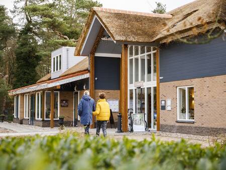 2 people walking in front of the central building Roompot De Veluwse Hoevegaerde