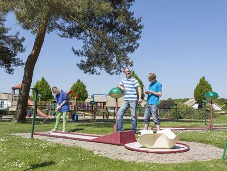 People playing golf on the mini golf course of the Roompot De Veluwse Hoevegaerde holiday park