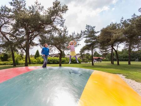 2 children jump on the air trampoline in the playground at Roompot De Veluwse Hoevegaerde