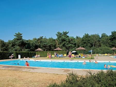 People swim in the outdoor pool of the Roompot De Veluwse Hoevegaerde holiday park