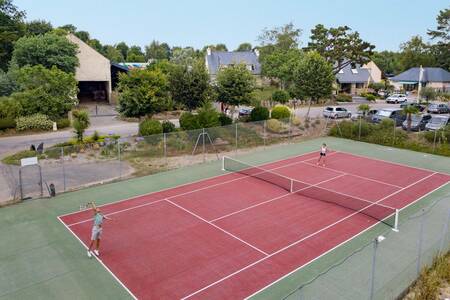 People playing tennis on the tennis court of the Roompot Deux Fontaines holiday park