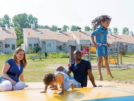 children jump on the air trampoline in a playground at holiday park Roompot Duinresort Dunimar