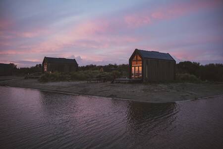 Holiday homes at dusk on the small-scale Roompot ECO Grevelingen beach