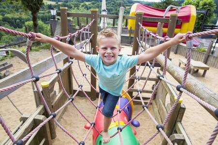 Child plays in a playground at the Roompot Eifelpark Kronenburger See holiday park