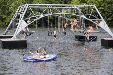 Children play in the water of the reservoir next to Roompot Eifelpark Kronenburger See