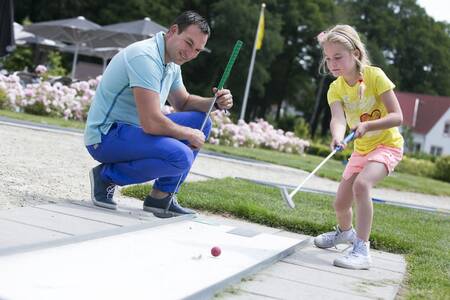 Family playing golf on the miniature golf course of Roompot Ferienresort Bad Bentheim holiday park