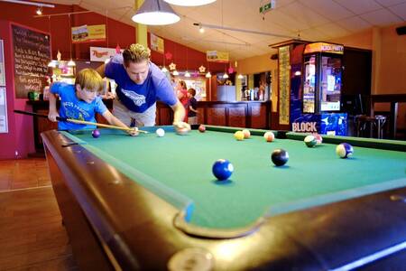 Father and son playing pool in the cafe at Roompot Ferienresort Cochem