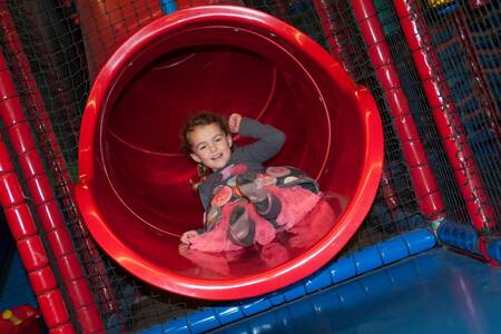 Child on a slide in the indoor playground at Roompot Ferienresort Cochem