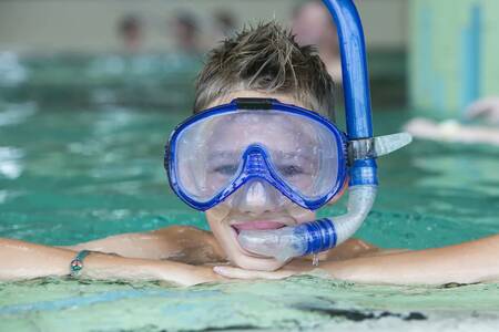 Boy with diving mask and snorkel in the pool of Roompot Ferienresort Cochem