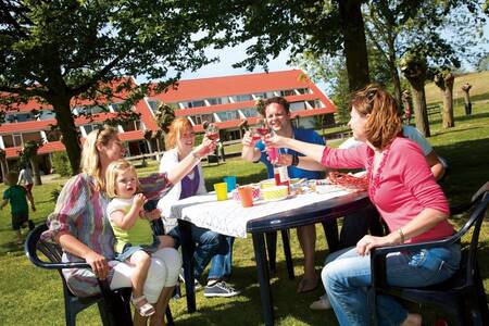 Family on a terrace in front of an apartment complex at Roompot Holiday Park Aquadelta