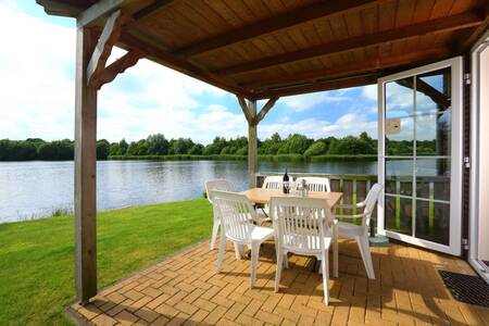 Covered terrace on the water of a holiday home at Roompot Holiday Park Emslandermeer