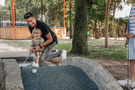 People play golf on the miniature golf course of Roompot Vakantiepark Kijkduin