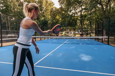 Man and woman are playing tennis on the tennis court of Roompot Vakantiepark Kijkduin