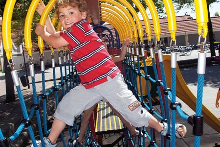 Child playing in a playground at Roompot Holiday Park Aquadelta