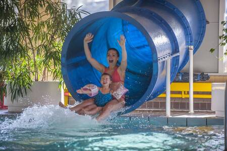 Mother and daughter on the slide in the indoor pool of Roompot Holiday Park Aquadelta