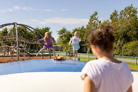 Children jump on the air trampoline in the playground at Roompot Holiday Park Callassande