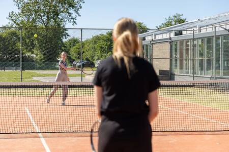 People playing tennis on the tennis court of Roompot Holiday Park Callassande