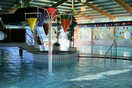 The indoor pool with large water buckets at Roompot Holiday Park Emslandermeer