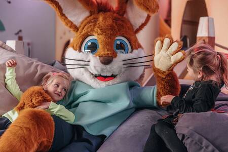 Child cuddles with Koos rabbit at Roompot Vakantiepark Kijkduin