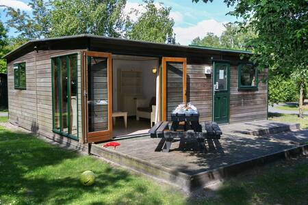 Chalet with a picnic table on the veranda at Roompot Vakantiepark Kijkduin