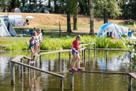 Children on a balance beam over the water at the Roompot Hunzepark holiday park
