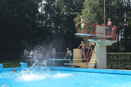 People on the diving board in the outdoor pool of the Roompot Hunzepark holiday park