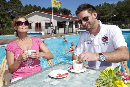 People on the terrace at the outdoor pool of holiday park Roompot Kustpark Egmond aan Zee