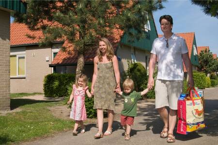 Family walks through holiday park Roompot Kustpark Klein Poelland
