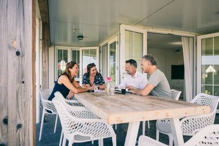 People at a table at a holiday home at the Roompot Noordzee holiday park Résidence Cadzand-Bad