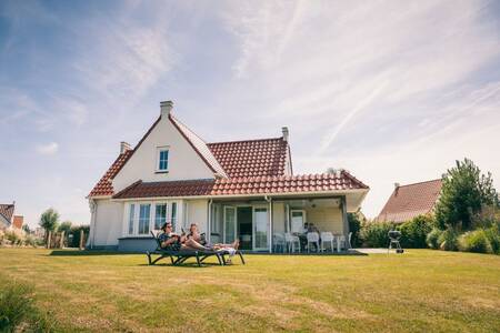 2 people in the garden of a detached holiday home at Roompot Noordzee Résidence Cadzand-Bad