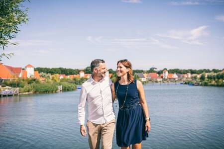 Man and woman in front of the lake at the Roompot Noordzee holiday park Résidence Cadzand-Bad