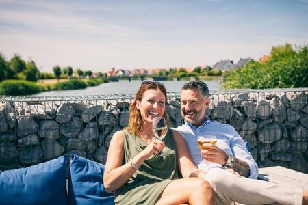 Man and woman enjoying a drink on the terrace at Roompot Noordzee Résidence Cadzand-Bad