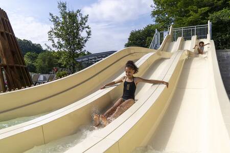 Children slide down the large slide in the swimming pool of the Roompot Parc la Clusure holiday park
