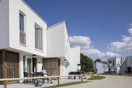 A man on a terrace of a holiday home at the Roompot Park Eksel holiday park