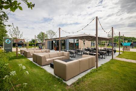 The Grab & go with lounge sets on the terrace of the Roompot Park Wijdenes holiday park