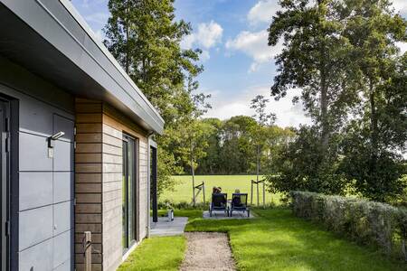 People are sitting in the garden at their holiday home at the Roompot Park Wijdenes holiday park