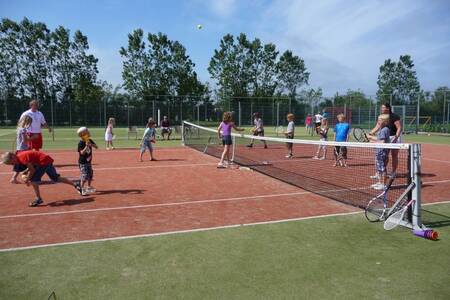People are playing tennis on the tennis court of Roompot Holiday Park Callassande