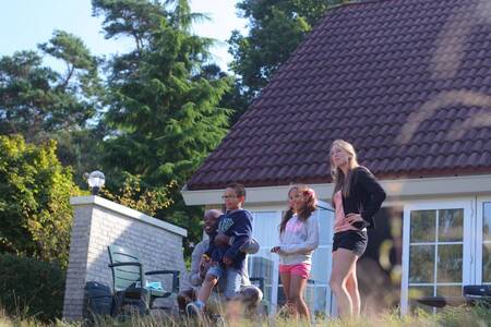 People in the garden of a holiday home at Roompot Holiday Park Hellendoorn