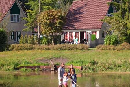 Family on a raft in the recreational lake at Roompot Holiday Park Hellendoorn