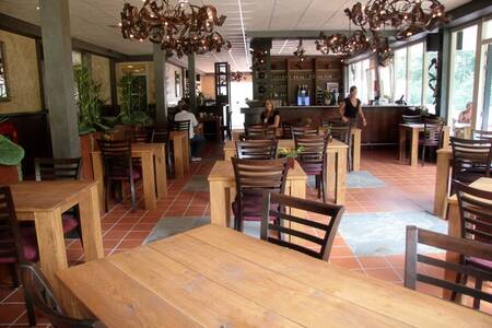 Tables with chairs in the restaurant at Roompot Holiday Park Herperduin